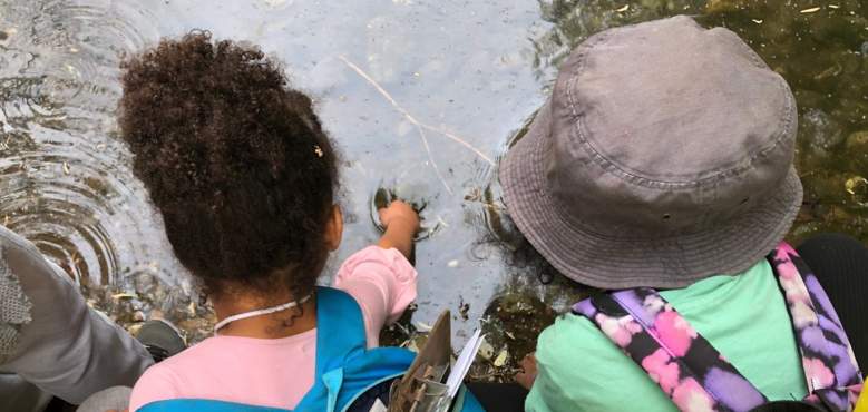 Photo of two children playing in the water at Soil Born Farms